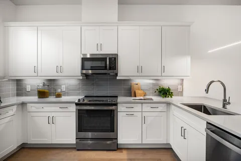 a kitchen with white cabinets and white appliances