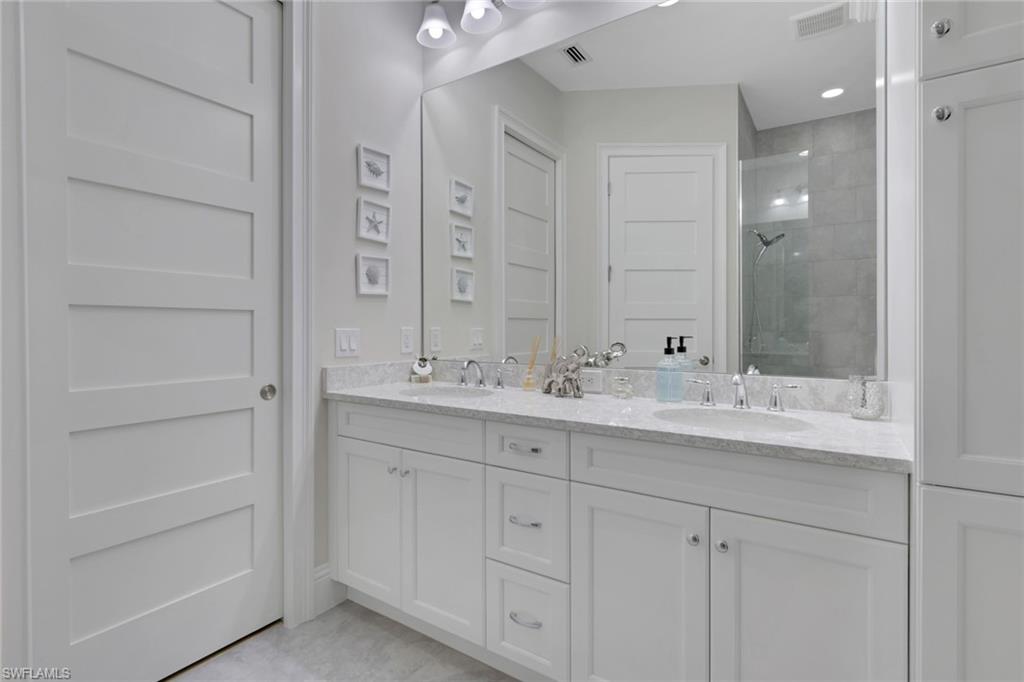 8861 Yucatan Court Naples, FL 34113 - Photo 13 of 39 a bathroom with a double vanity sink and a mirror