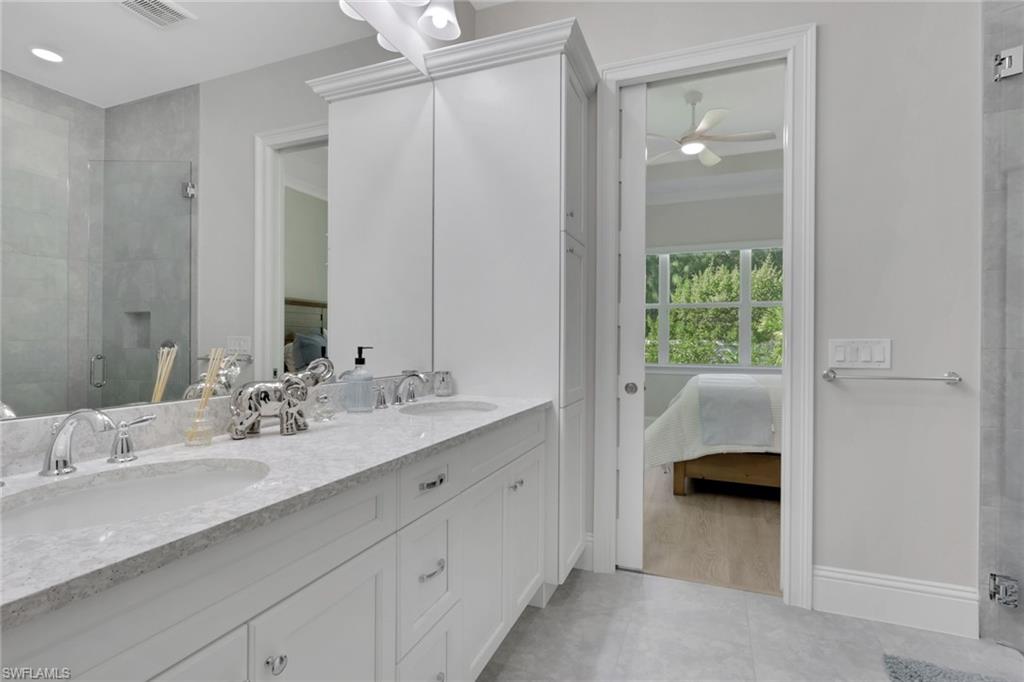 8861 Yucatan Court Naples, FL 34113 - Photo 15 of 39 a en suite bathroom with a double vanity sink a mirror and a shower