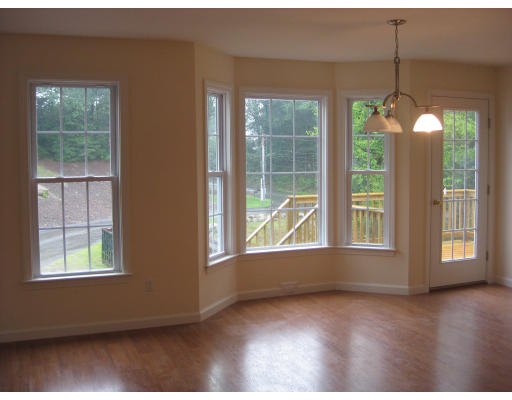 14 Reed Lane, Unit 14 Littleton, MA 01460 - Photo 3 of 12 an empty room with wooden floor and windows