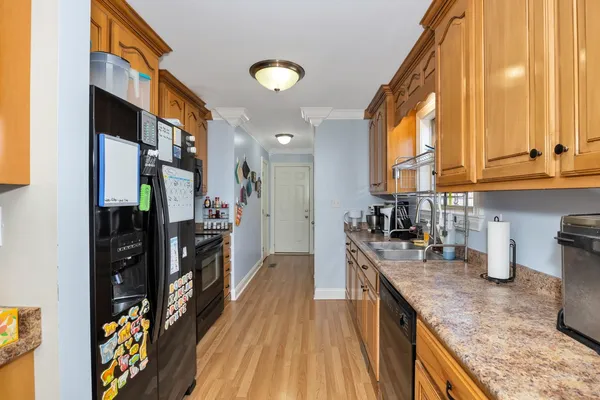 a kitchen with stainless steel appliances granite countertop sink stove top oven and cabinets