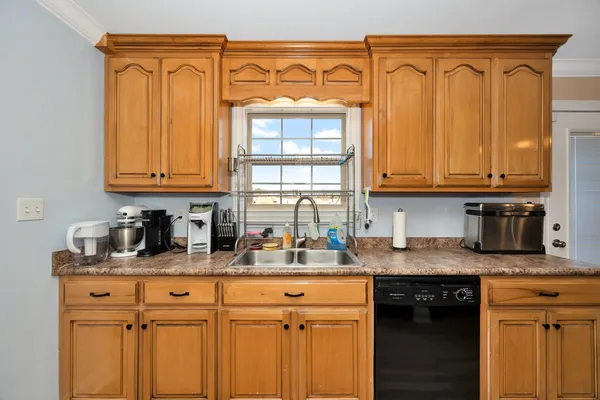 a kitchen with stainless steel appliances granite countertop a sink a stove cabinets and a window