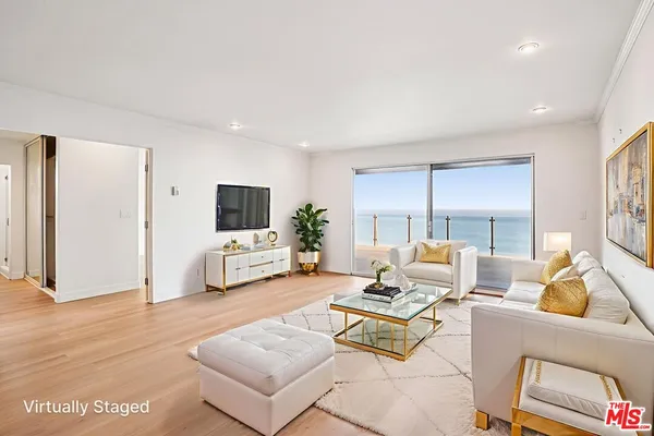 a living room with furniture a flat screen tv and a large window