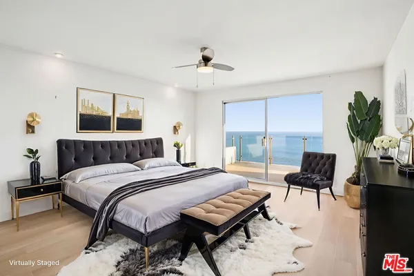 a bedroom with a large bed and a potted plant