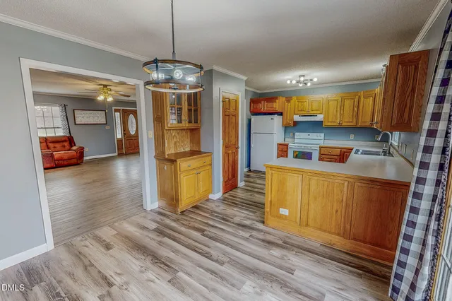 a kitchen with stainless steel appliances granite countertop a refrigerator a stove and a wooden floors