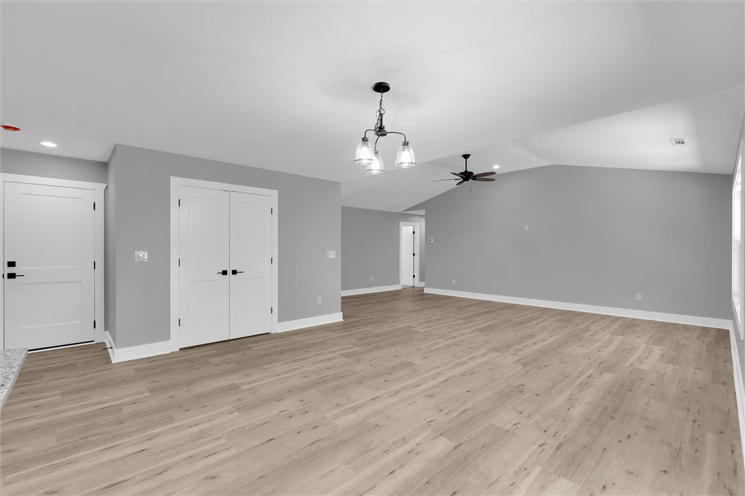 1747 A State Rd S-4-97 Anderson, SC 29621 - Photo 11 of 47 Natural wood flooring complements this inviting living space, crowned by vaulted ceilings and a modern light fixture.