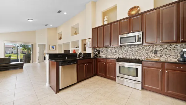 a kitchen with stainless steel appliances granite countertop a stove a sink and a microwave