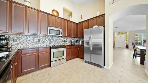 a kitchen with stainless steel appliances granite countertop a refrigerator and a stove top oven