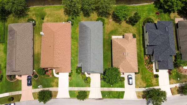 an aerial view of a house with a yard and fountain