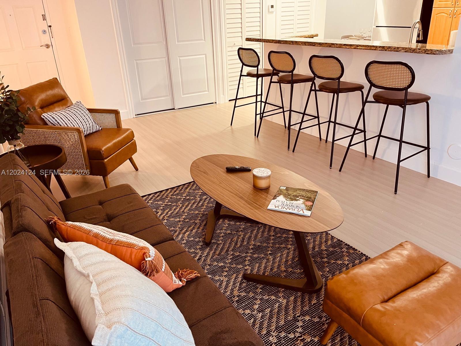 a living room with furniture a rug and white walls