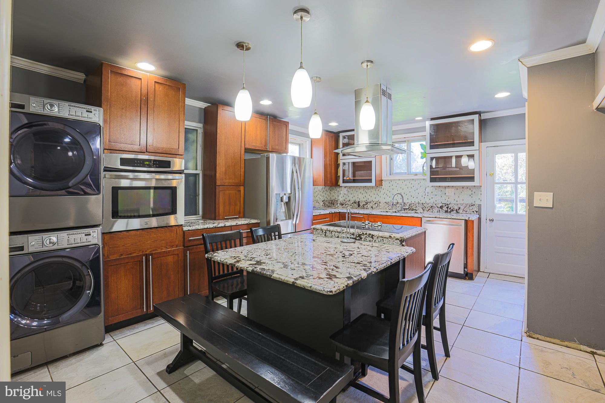 7215 Rockridge Road Baltimore, MD 21207 - Photo 12 of 62 a kitchen with stainless steel appliances granite countertop a stove a refrigerator a oven a sink with a dining table and chairs