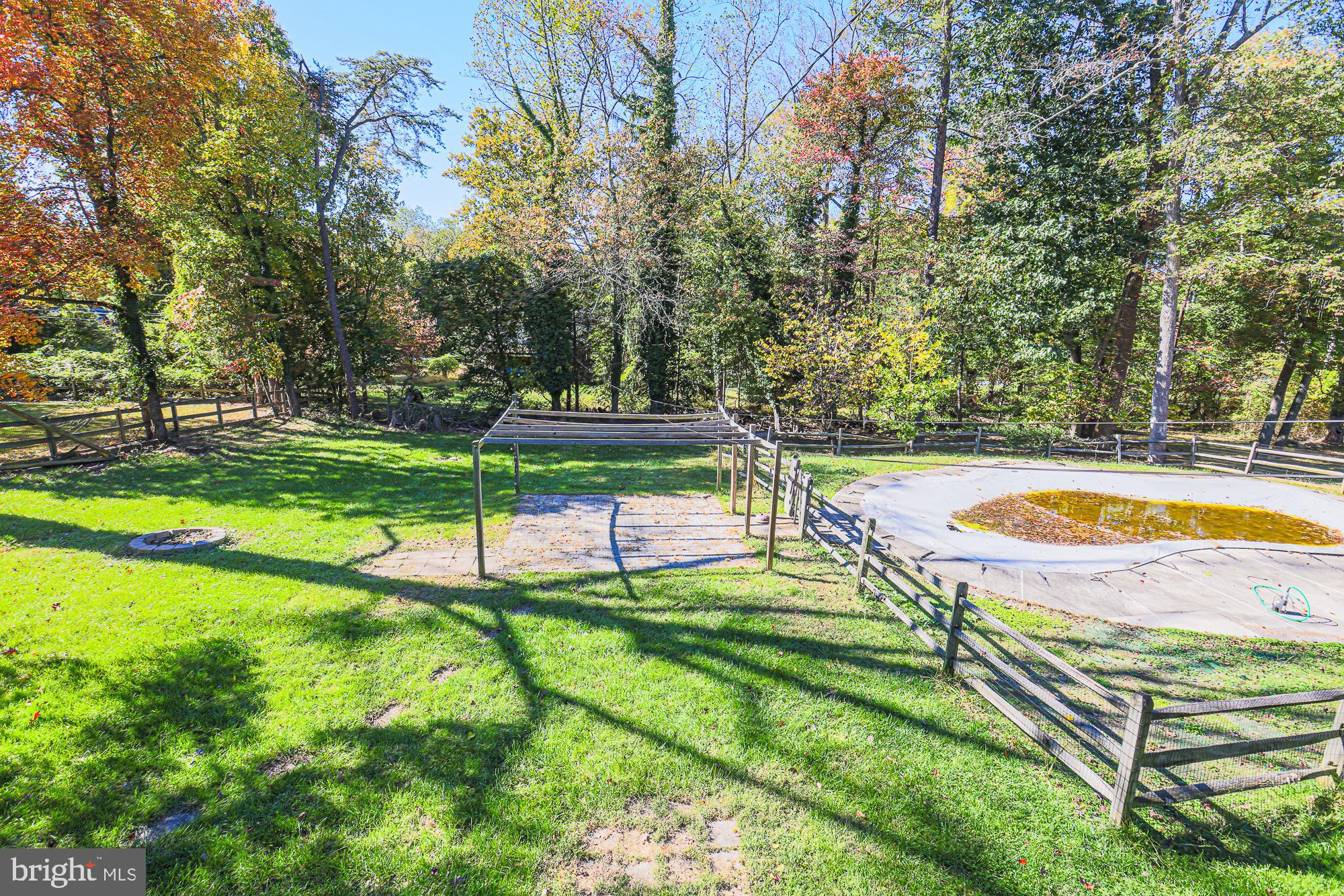 7215 Rockridge Road Baltimore, MD 21207 - Photo 53 of 62 a view of a swimming pool with a yard and large trees