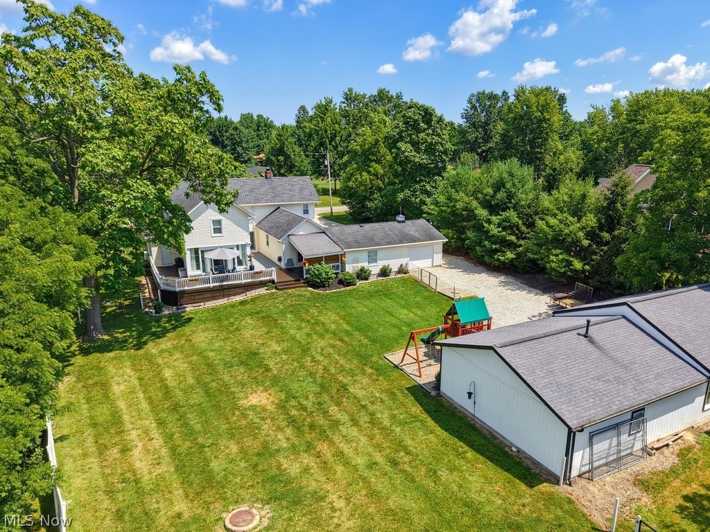 23055 Snell Road Columbia Station, OH 44028 - Photo 44 of 50 Spacious property featuring a large manicured lawn, an expansive wooden deck with white railing, and mature trees providing natural screening