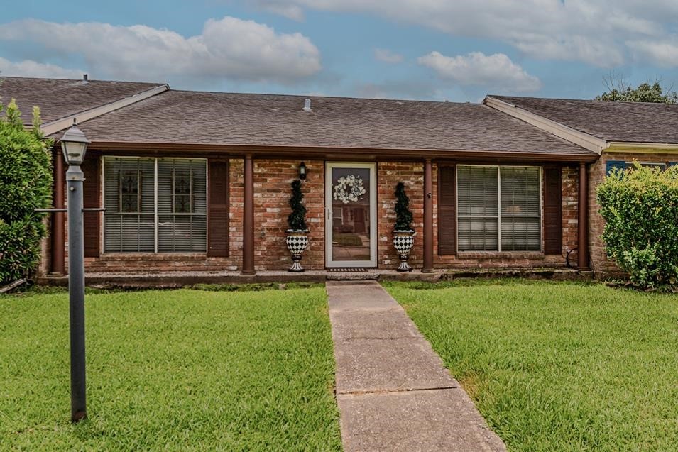 front view of a brick house with a yard