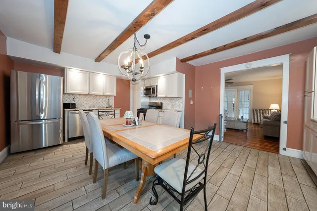 a kitchen with stainless steel appliances a refrigerator sink and wooden floor