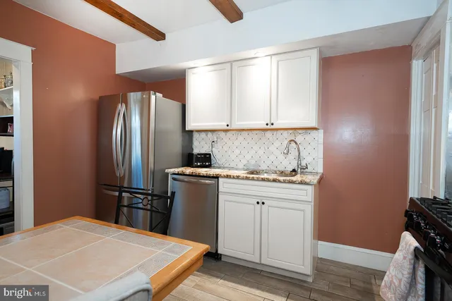 a dining room with stainless steel appliances kitchen island granite countertop furniture and wooden floor