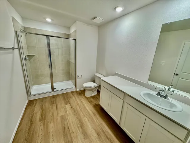 a spacious bathroom with a granite countertop sink toilet and shower