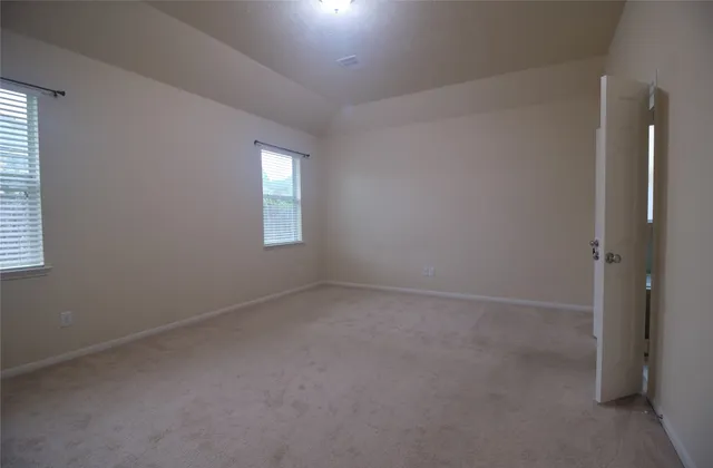 an empty room with windows and closet