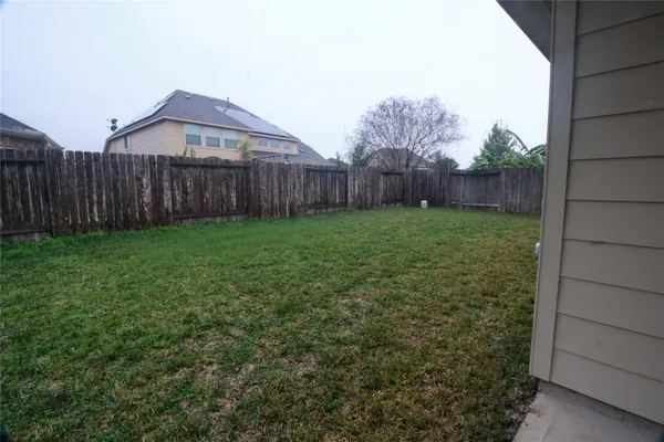 a view of a backyard with wooden fence