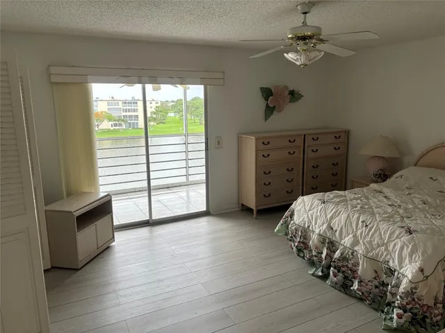 a spacious bedroom with a bed a dresser and a chandelier