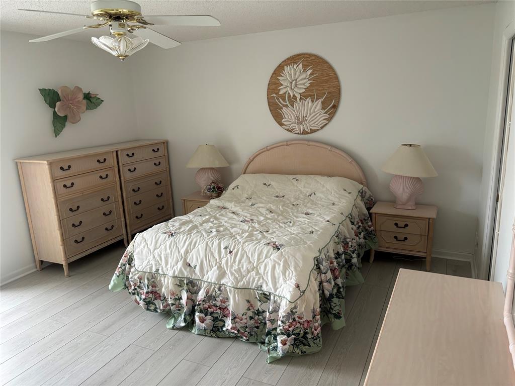 4053 Cornwall C, Unit 4053 Boca Raton, FL 33434 - Photo 7 of 12 a bedroom with a bed and a chandelier