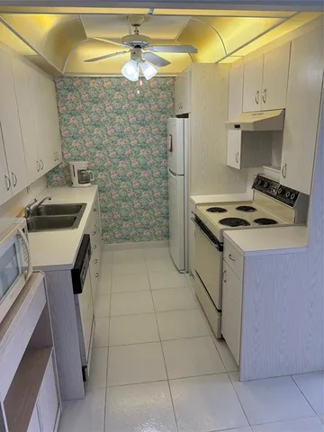 a kitchen that has a stove a sink and a refrigerator