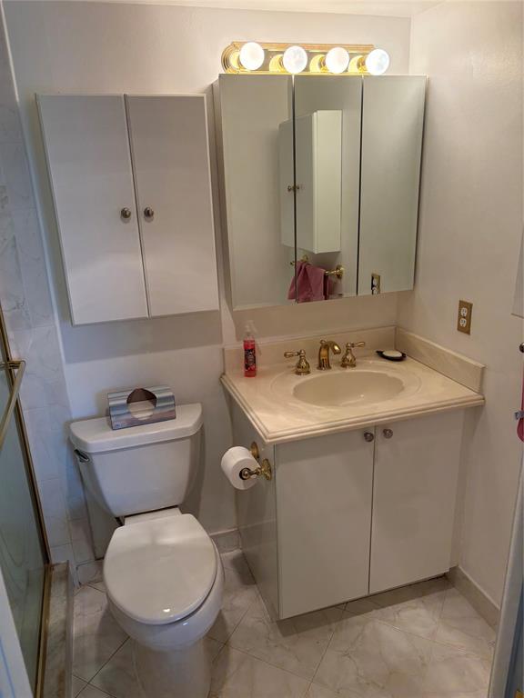 4053 Cornwall C, Unit 4053 Boca Raton, FL 33434 - Photo 10 of 12 a bathroom with a toilet sink and mirror