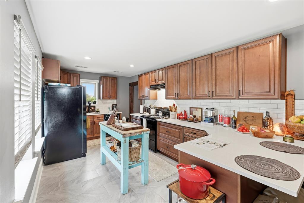 3300 Rigsby Lane Celina, TX 75009 - Photo 33 of 40 a kitchen with a sink stove and refrigerator