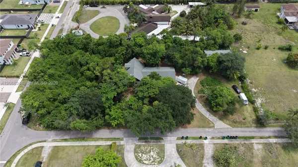 an aerial view of a house with outdoor space and a lake view in back