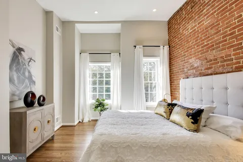 a spacious bedroom with a bed a window and potted plant