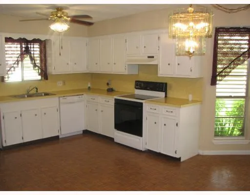 a kitchen with granite countertop white cabinets and white stainless steel appliances
