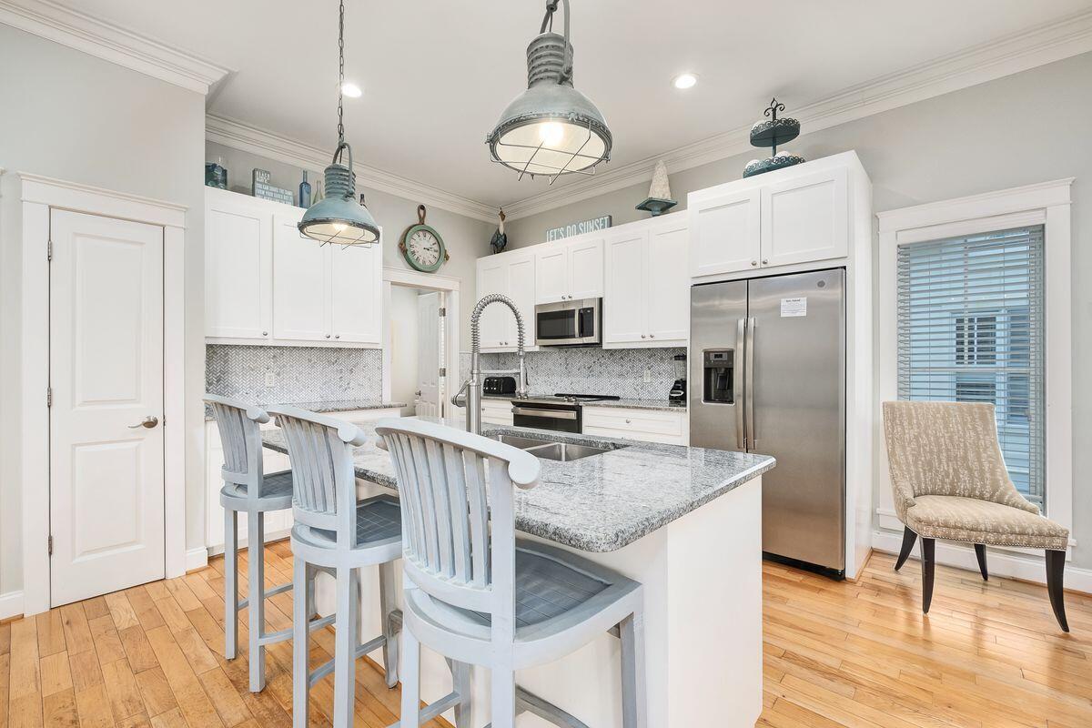 40 Chelsea Loop Road Santa Rosa Beach, FL 32459 - Photo 5 of 46 a kitchen with granite countertop a table chairs microwave and refrigerator