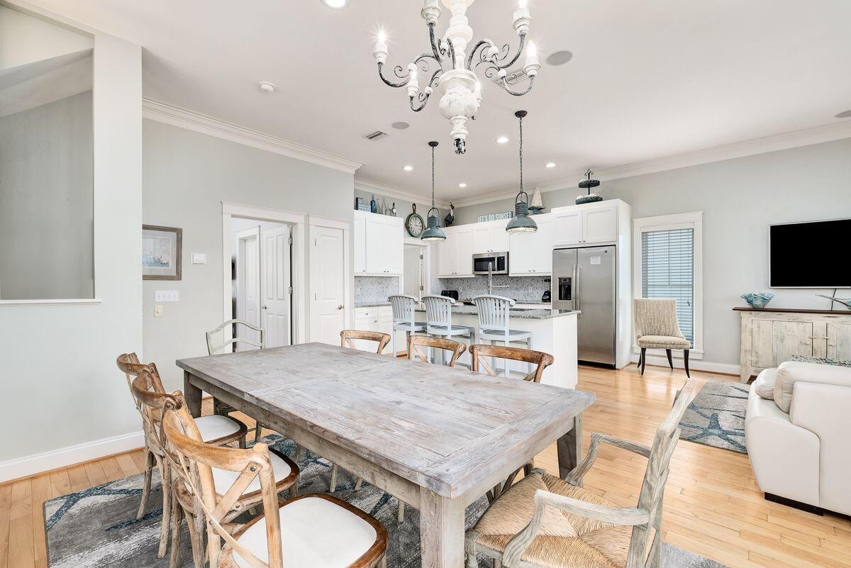 40 Chelsea Loop Road Santa Rosa Beach, FL 32459 - Photo 7 of 46 a dining room with stainless steel appliances kitchen island granite countertop a table chairs and a refrigerator