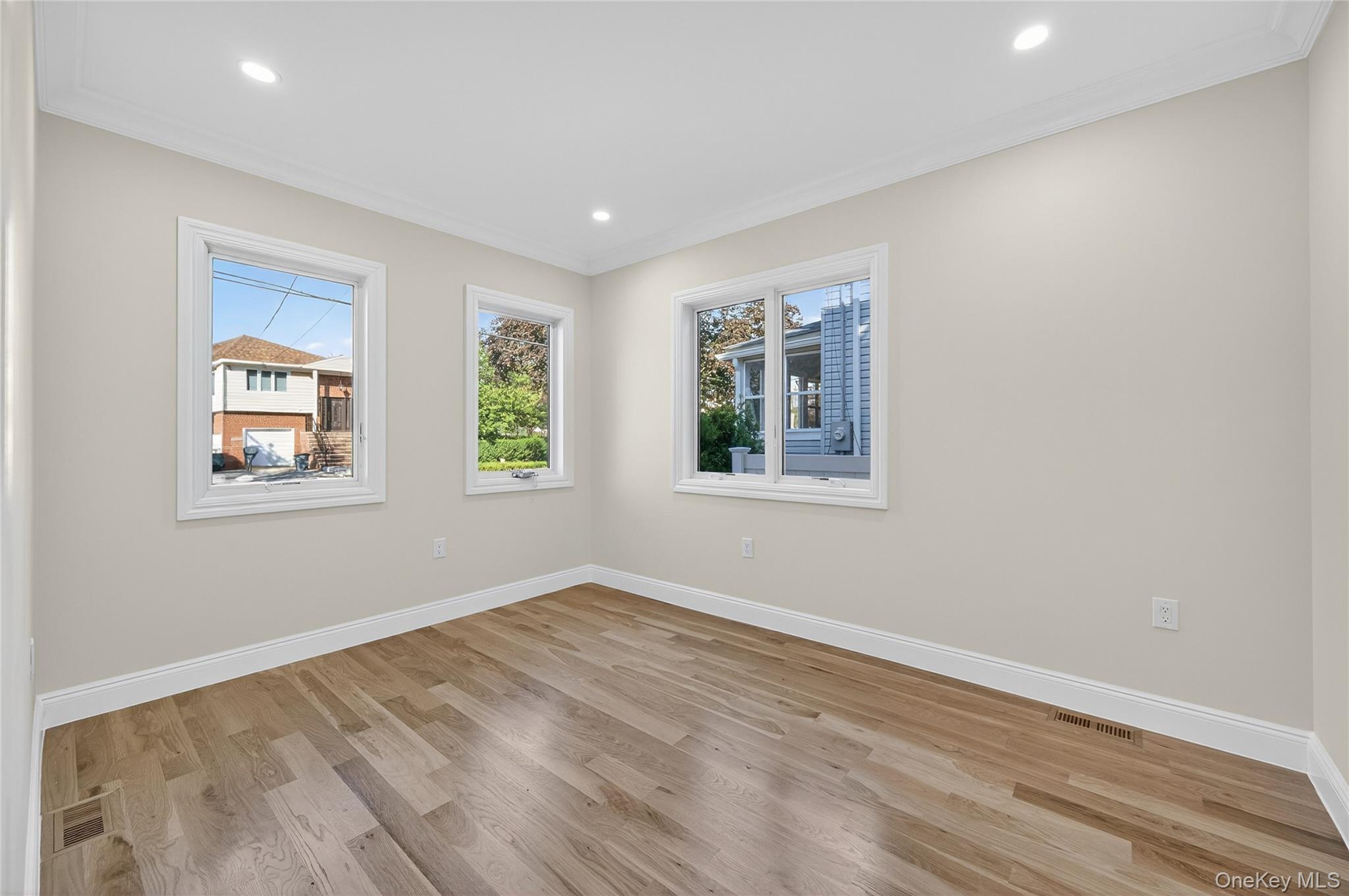80 Clapham Avenue Manhasset, NY 11030 - Photo 12 of 31 Unfurnished room featuring light wood-style floors, crown molding, and recessed lighting