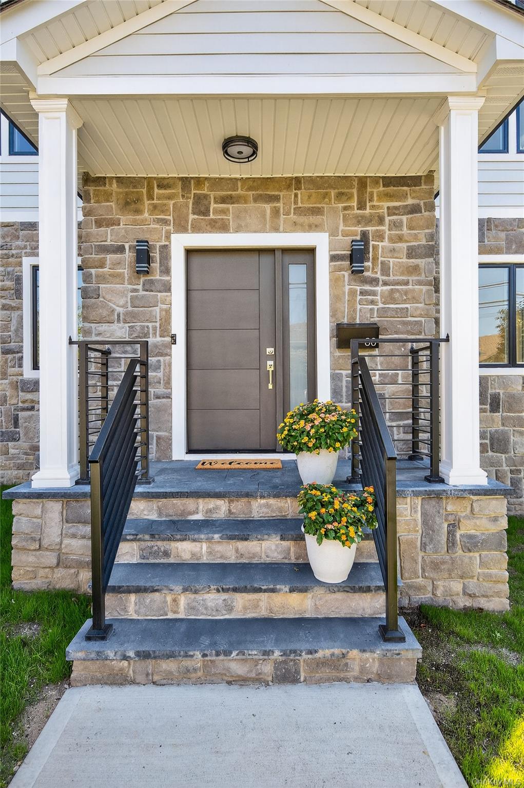 80 Clapham Avenue Manhasset, NY 11030 - Photo 13 of 31 Doorway to property with stone siding and covered porch
