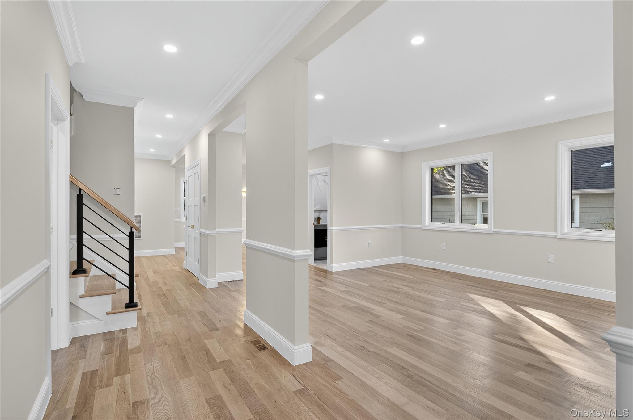 80 Clapham Avenue Manhasset, NY 11030 - Photo 2 of 31 Unfurnished living room featuring light wood-style floors, crown molding, recessed lighting, and stairway