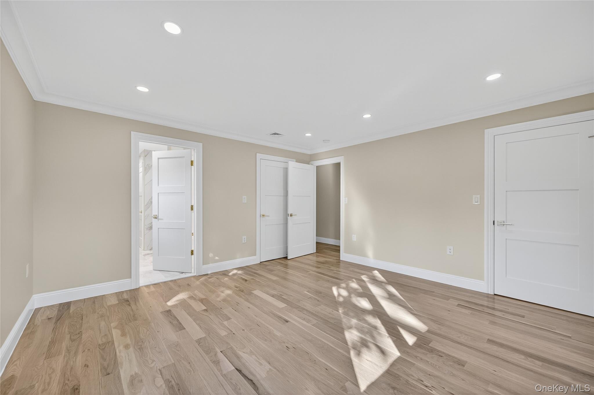 80 Clapham Avenue Manhasset, NY 11030 - Photo 22 of 31 Unfurnished bedroom with recessed lighting, ornamental molding, light wood finished floors, and ensuite bathroom