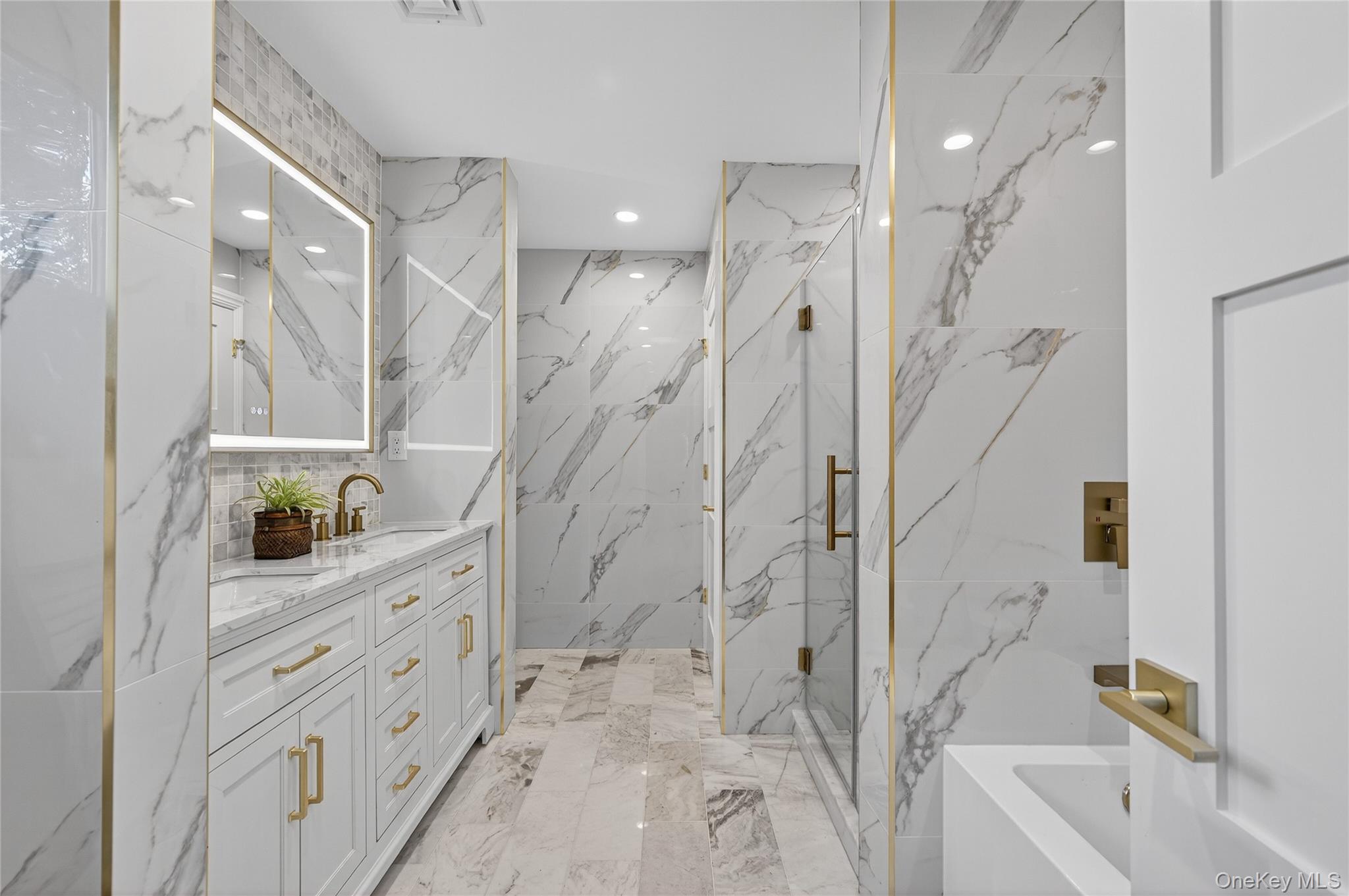 80 Clapham Avenue Manhasset, NY 11030 - Photo 25 of 31 Bathroom featuring a marble finish shower, double vanity, stone wall, light marble finish flooring, and recessed lighting