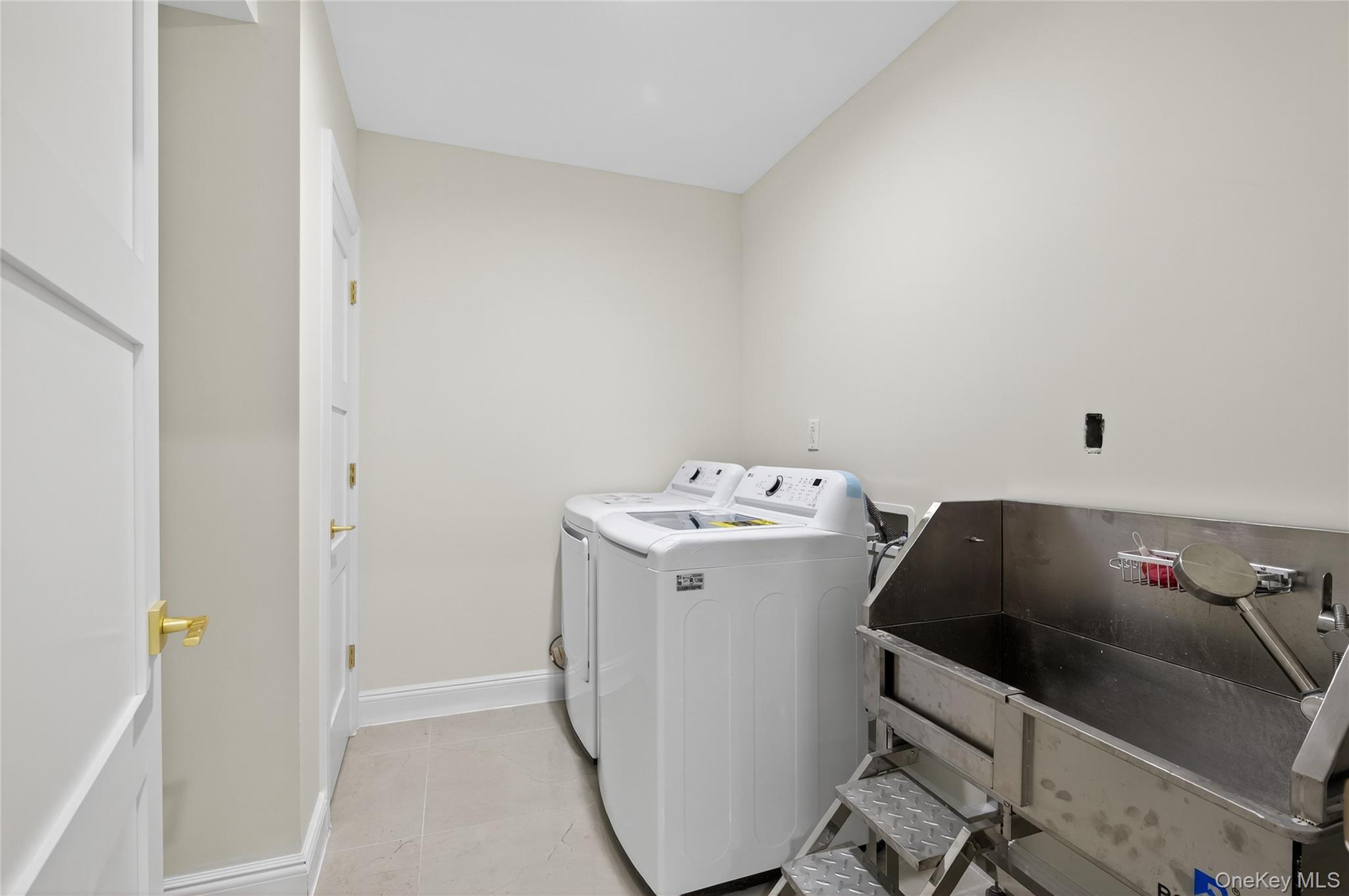 80 Clapham Avenue Manhasset, NY 11030 - Photo 27 of 31 Washroom featuring light tile patterned flooring and washer and clothes dryer