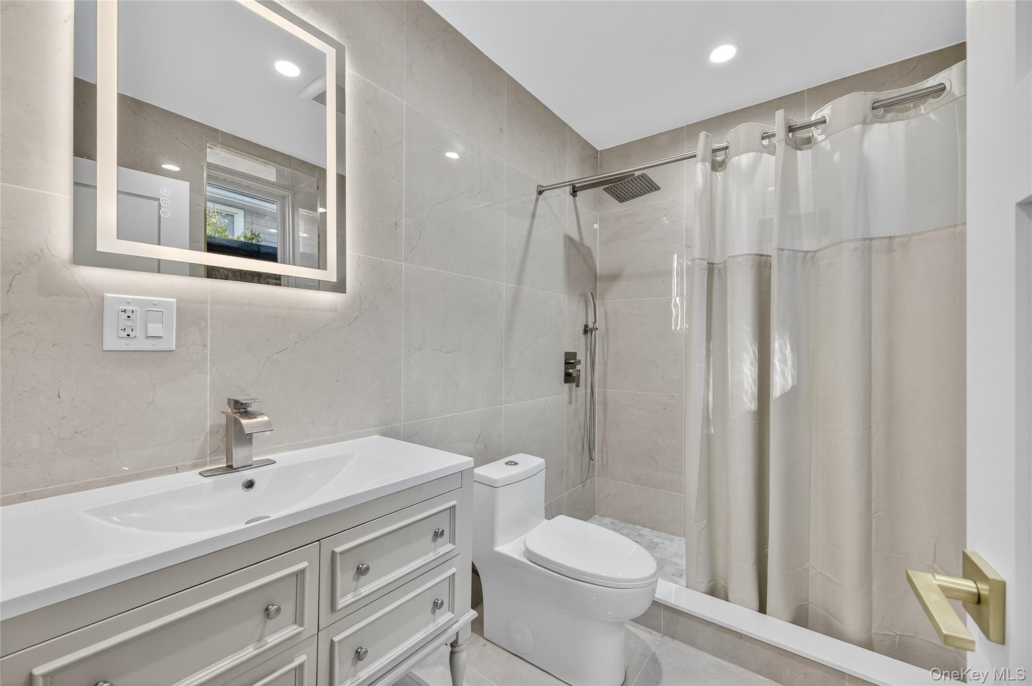 80 Clapham Avenue Manhasset, NY 11030 - Photo 28 of 31 Bathroom featuring tile walls, vanity, a stall shower, recessed lighting, and tasteful backsplash