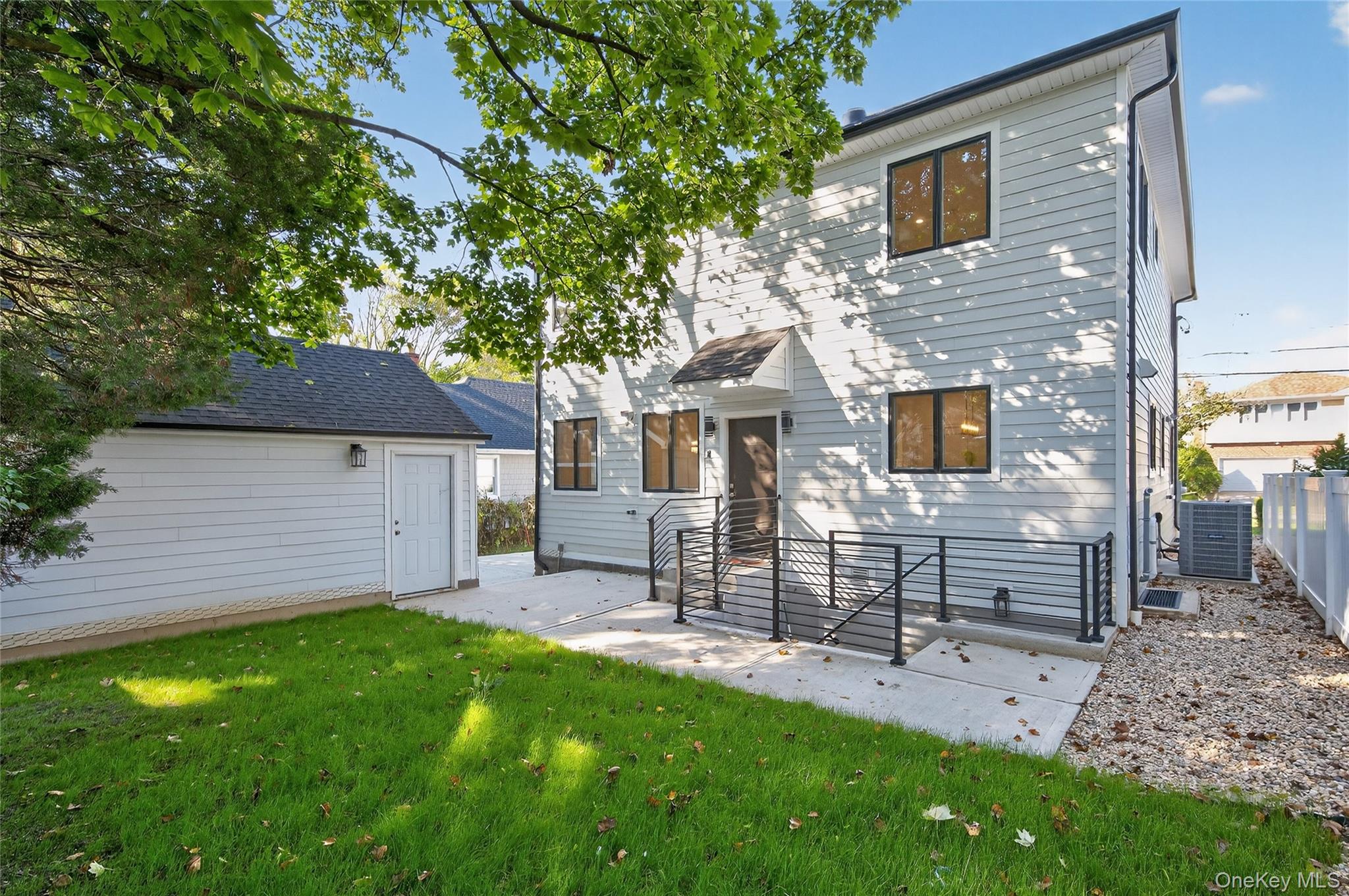 80 Clapham Avenue Manhasset, NY 11030 - Photo 30 of 31 View of front facade featuring a front yard and a patio