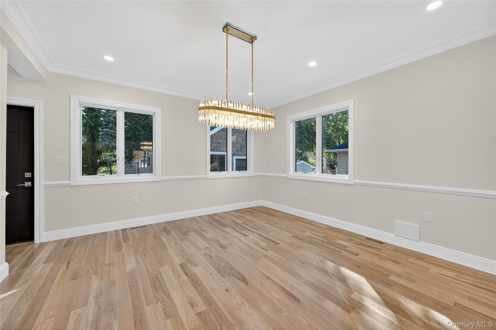 80 Clapham Avenue Manhasset, NY 11030 - Photo 6 of 31 Unfurnished dining area featuring crown molding, light wood-style flooring, recessed lighting, and a chandelier