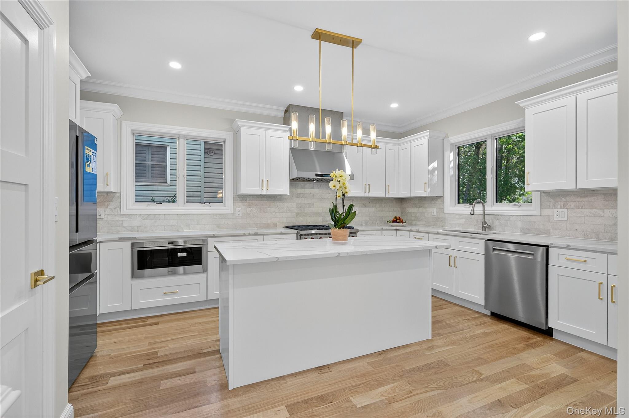 80 Clapham Avenue Manhasset, NY 11030 - Photo 10 of 31 Kitchen featuring ornamental molding, pendant lighting, backsplash, dishwasher, and a kitchen island