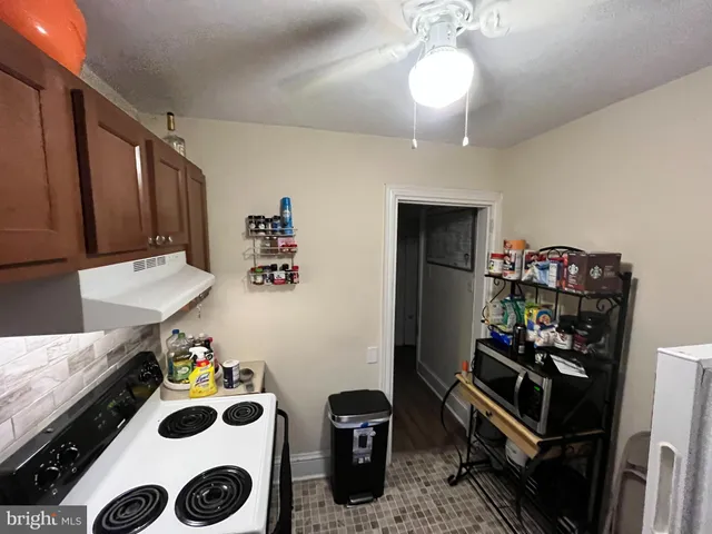 a kitchen with a refrigerator and a stove top oven