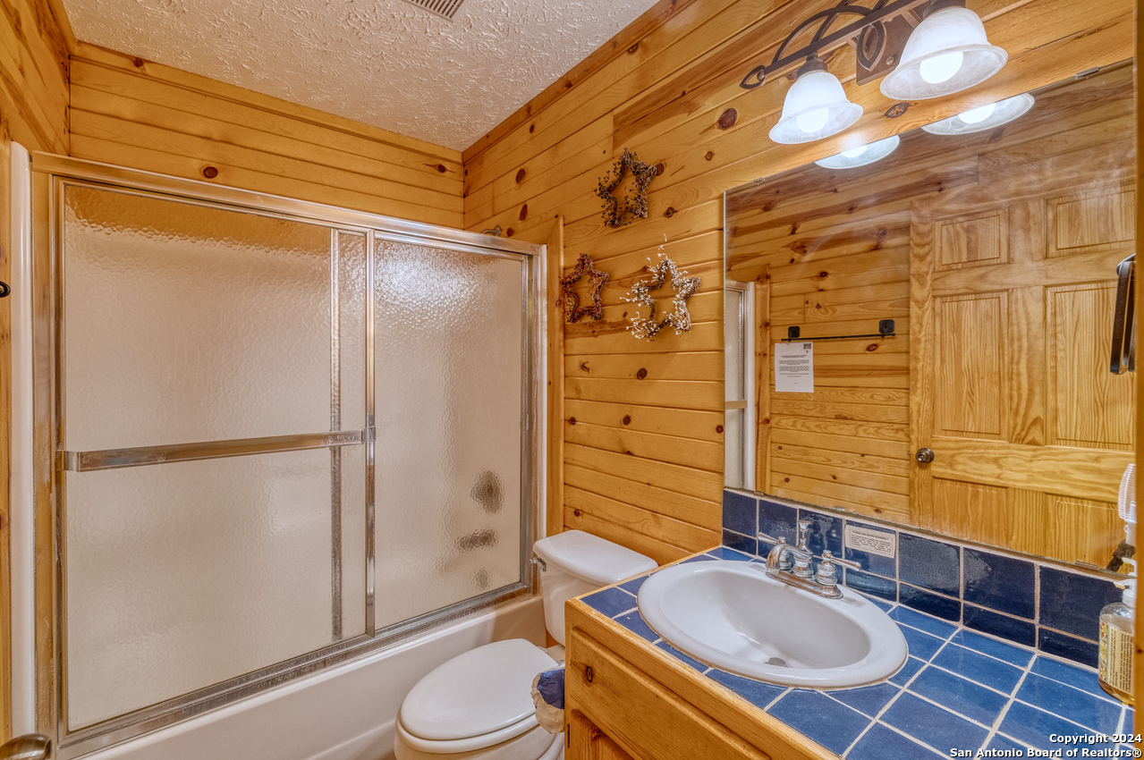 65 Comanche Crk Road Concan, TX 78838 - Photo 13 of 24 a bathroom with a sink toilet and shower