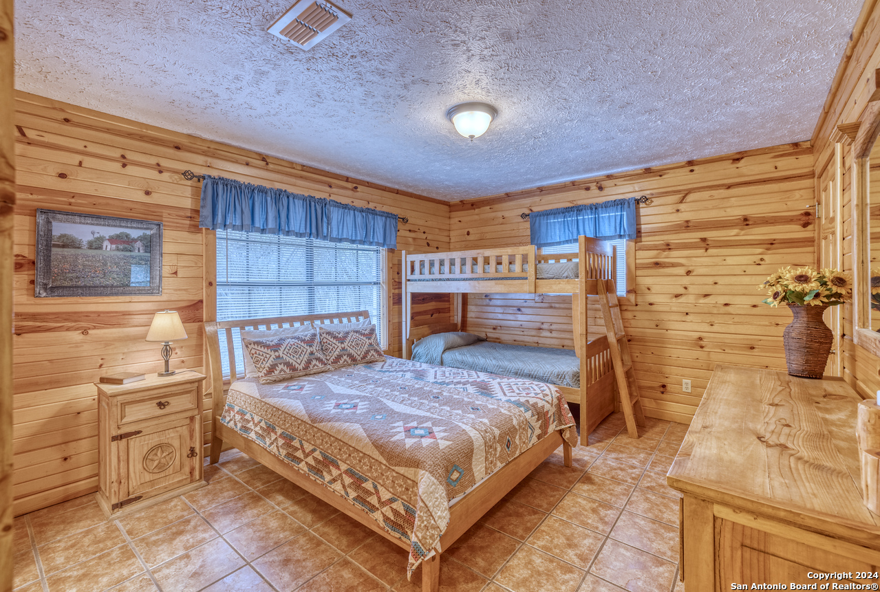 65 Comanche Crk Road Concan, TX 78838 - Photo 14 of 24 a bedroom with a bed and a table
