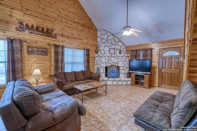 a living room with furniture a fireplace and a flat screen tv
