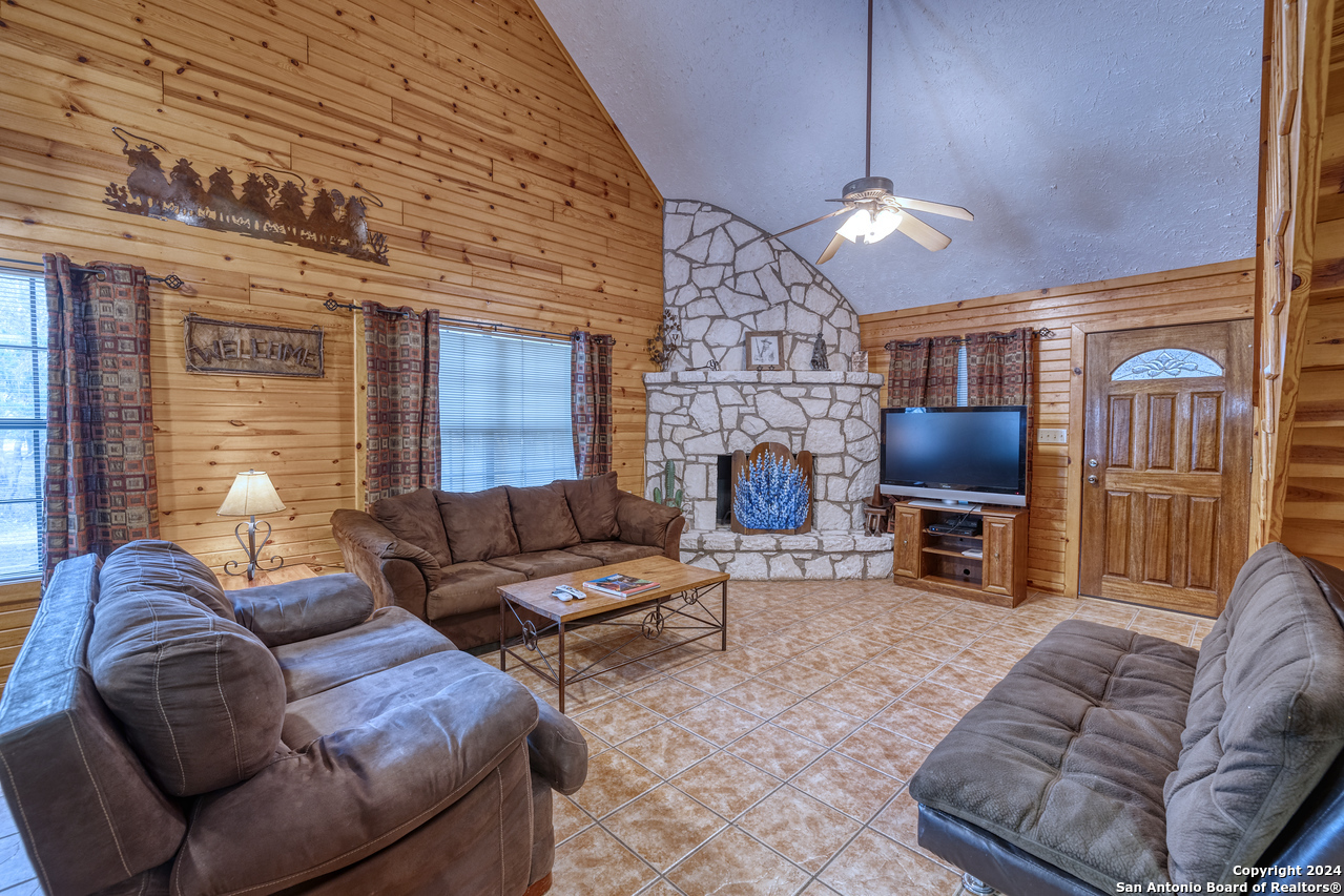 65 Comanche Crk Road Concan, TX 78838 - Photo 4 of 24 a living room with furniture a fireplace and a flat screen tv