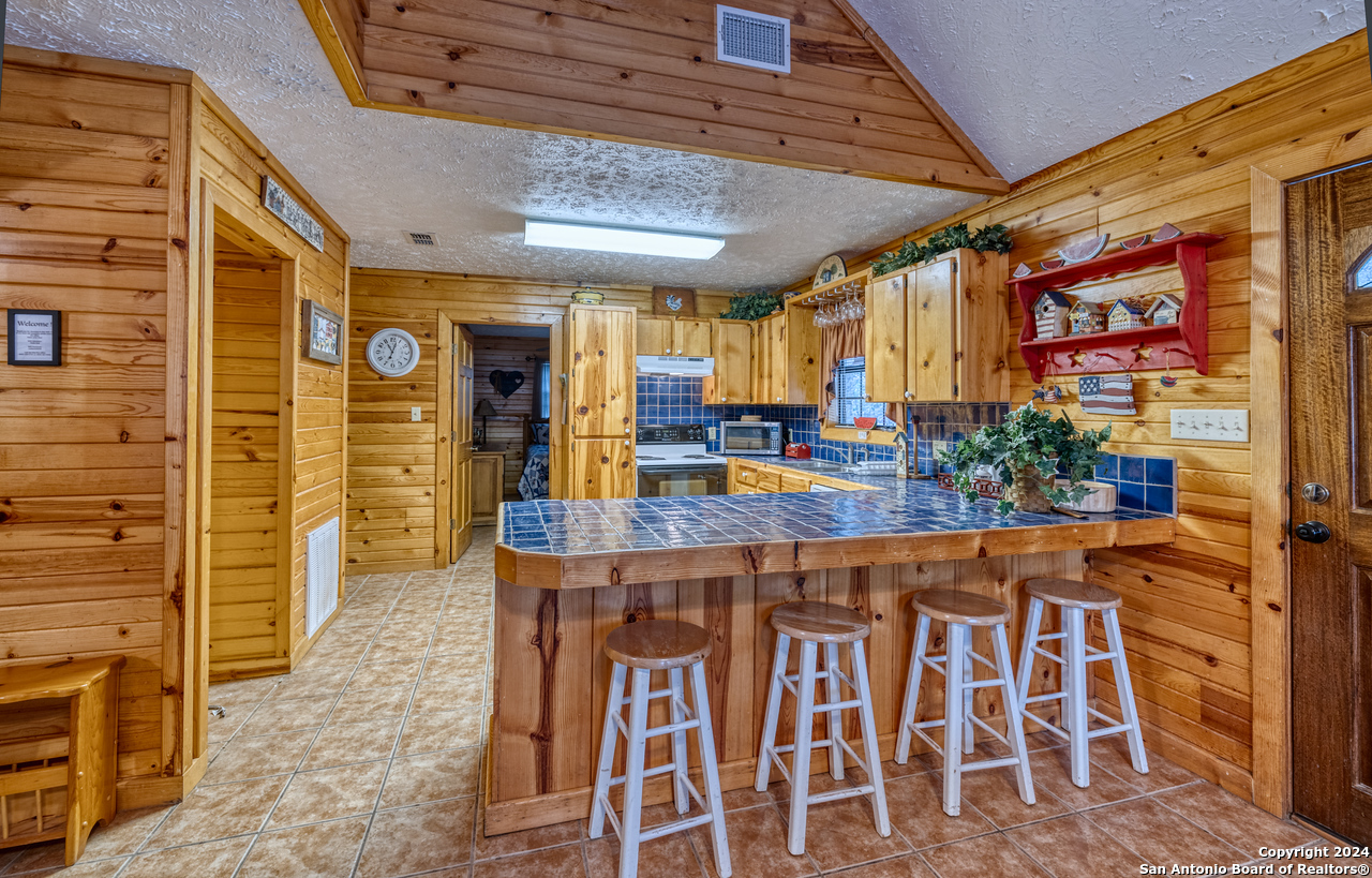 65 Comanche Crk Road Concan, TX 78838 - Photo 8 of 24 a view of a kitchen with a table and chairs in it