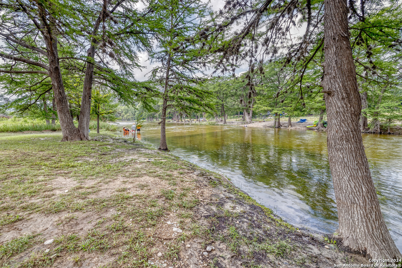 65 Comanche Crk Road Concan, TX 78838 - Photo 9 of 24 a view of a lake with a tree